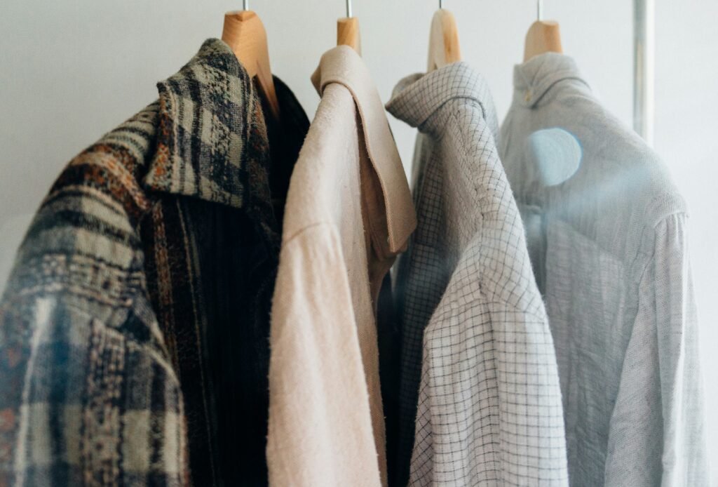 A close-up of sustainable clothing items hanging on wooden hangers, showcasing eco-friendly wardrobe choices.