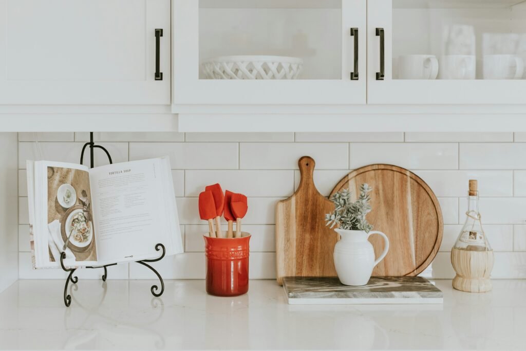 A collection of reusable kitchen items like silicon and bamboo spatulas, glass jars, and bamboo cutting boards.